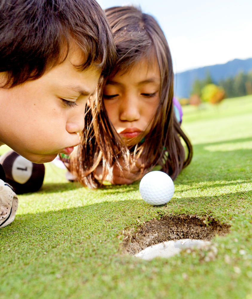 Golf players cheating blowing to get the ball into the hole